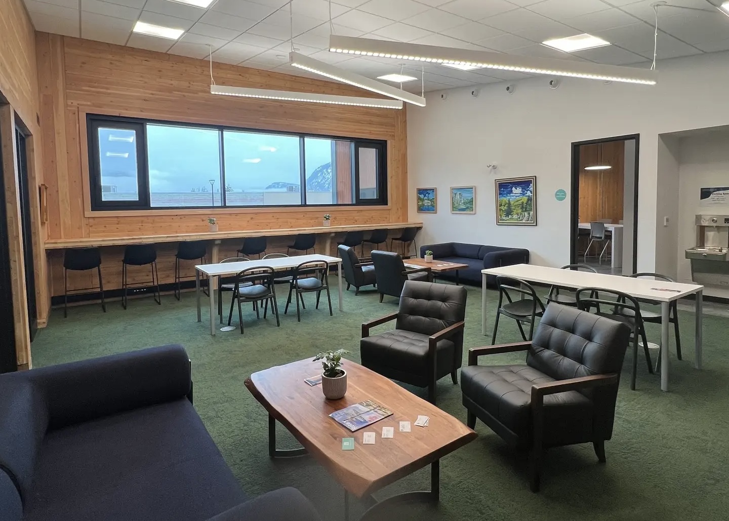 Co-working lounge at The Confluence with armchairs, timber accents and mountain views